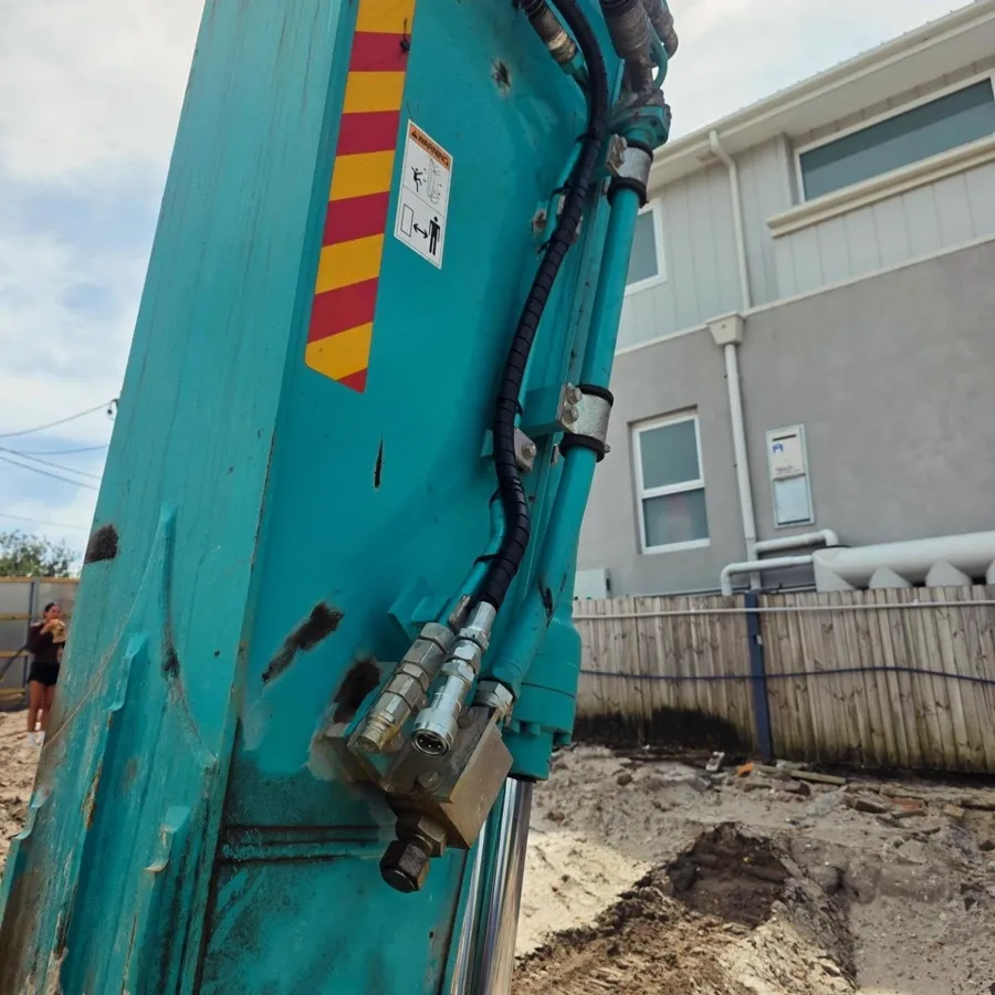 Hydraulic lines and quick couplers on an excavator arm